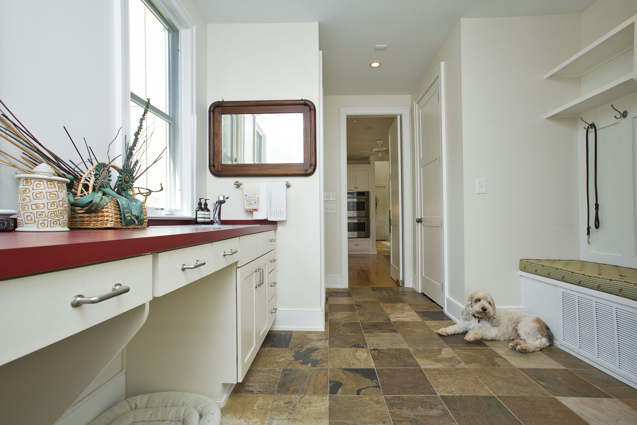 Bright and spacious mudroom leading off off from kitchen with bench seating and counters