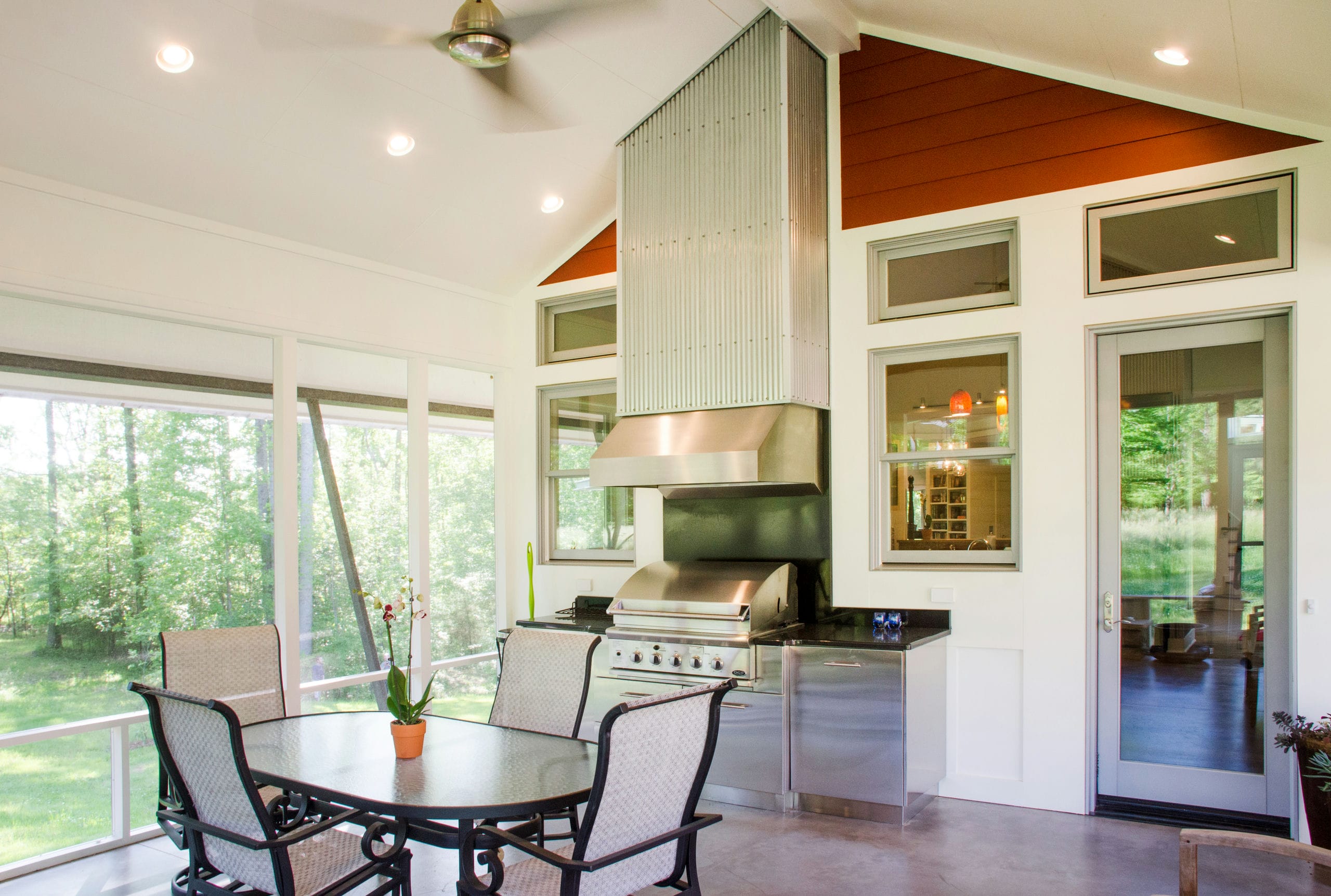 Screen porch with built contemporary built in grill with hood wrapped in corrugated metal