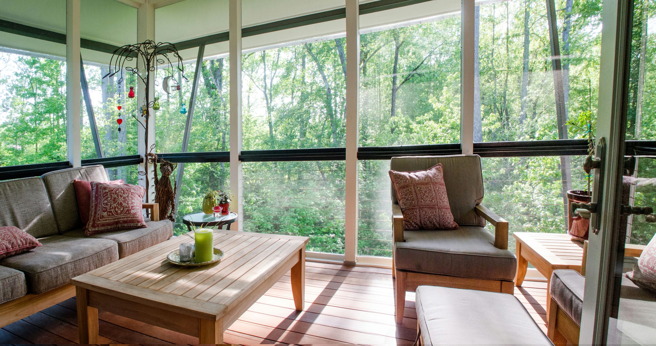 Upper level cantilevered screened porch with contemporary cable railings creates a sense of floating among the trees.