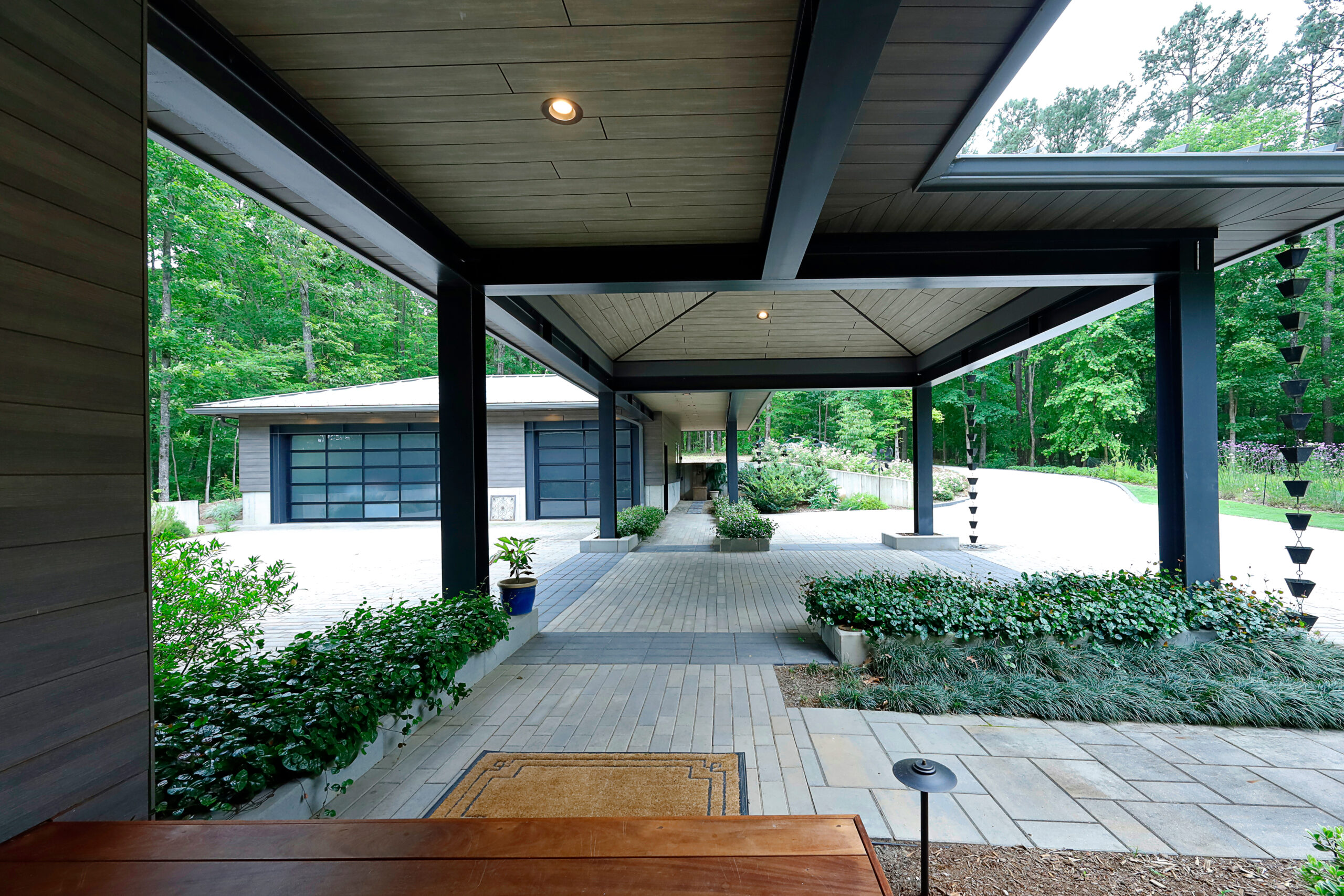 The porte cochere and breezeway, a series of roofed forms is articulated by heavy steel columns and beams.