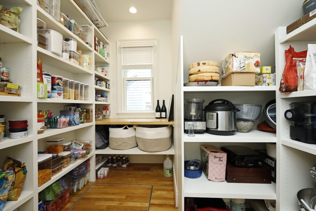 A large pantry with ample built-in storage, counter space, and a window to let in natural light.