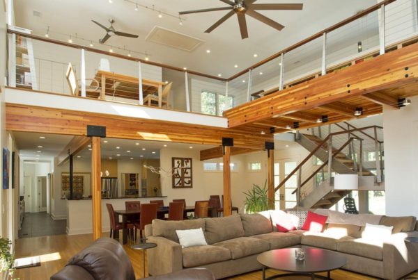 Bright open living room with high ceilings and loft space with glulam columns
