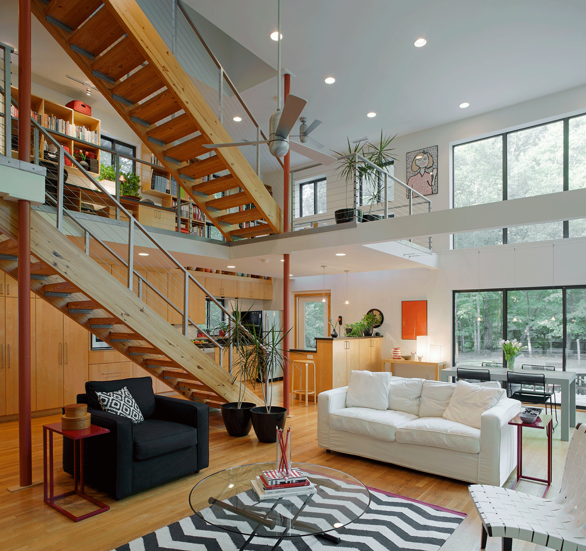 Eclectic furniture and art fill this creative and dramatic space. Large bands of windows illuminate the open living space while a cozy kitchen is tucked under an upstairs loft.