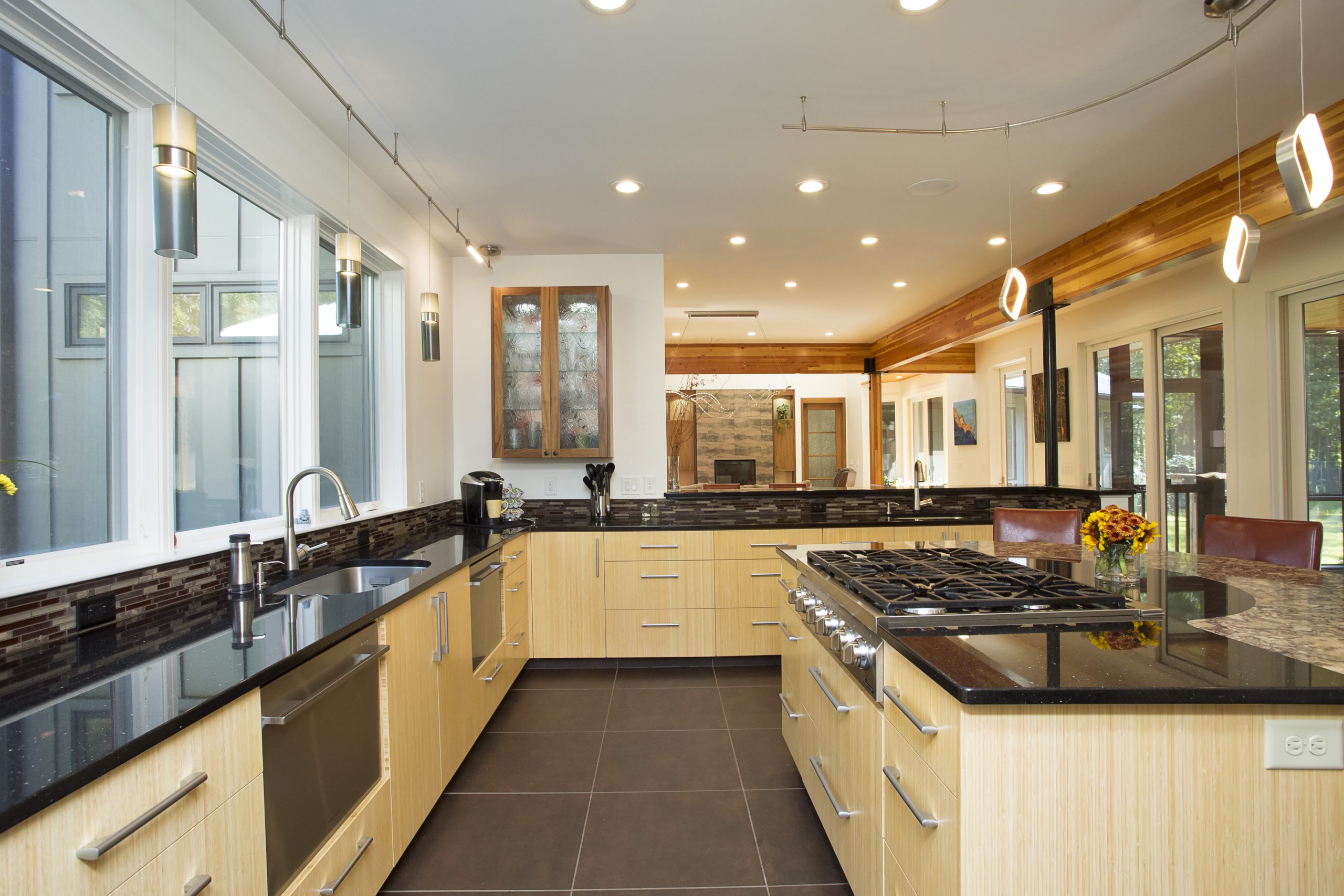 Modern kitchen with dark countertops and light wood outset cabinets
