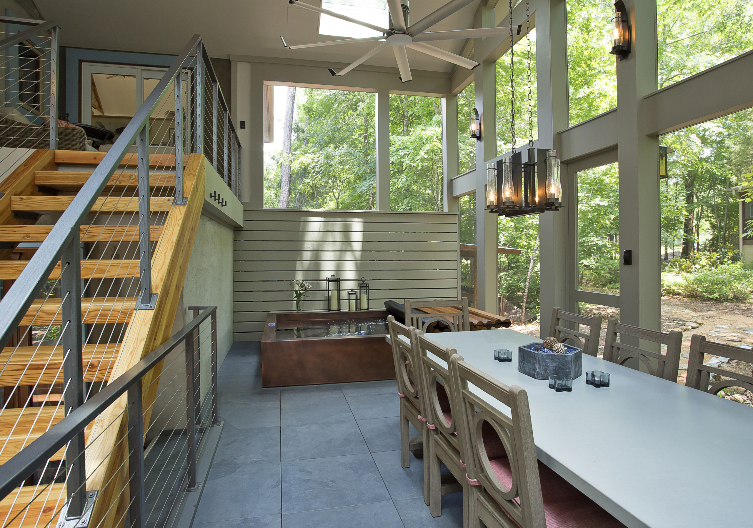 A view of the hot tub, dining table and stair in the screen porch