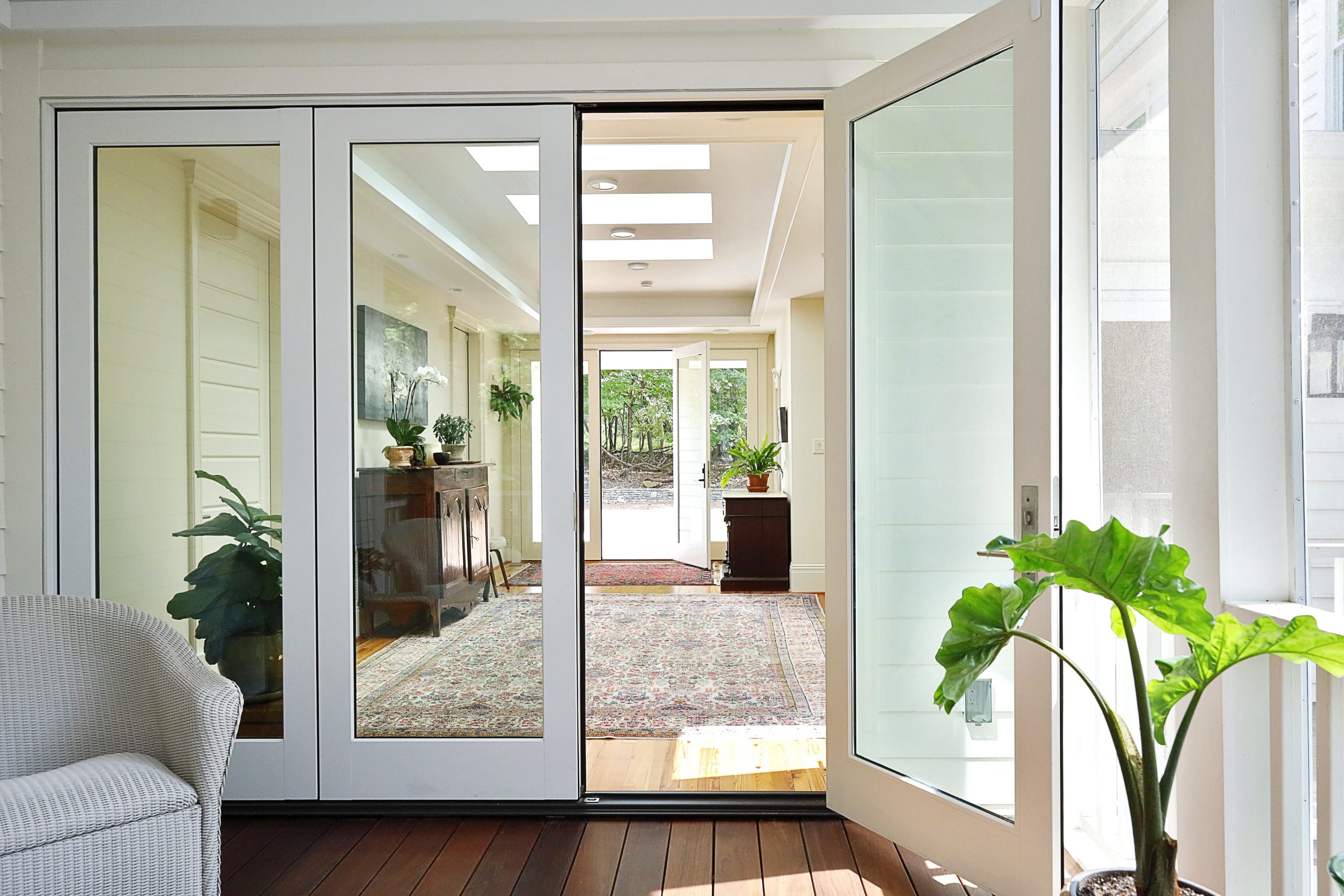 Large glass doors from the foyer to the screened porch create a strong visual connection and invite a feeling of the outdoors into the house