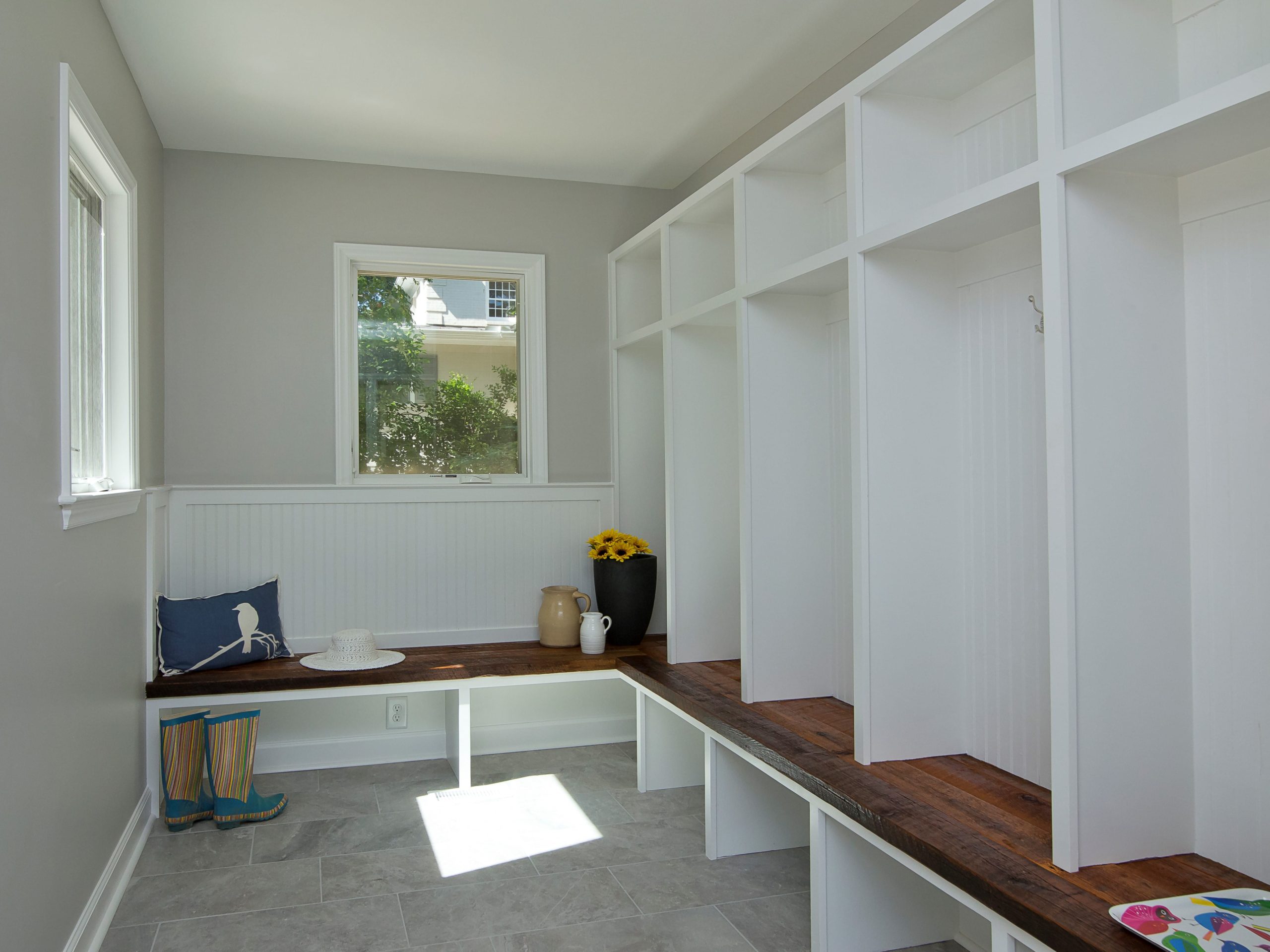 A minimal and elegant mudroom with built-in bench seating, shoe storage and hooks for hanging items