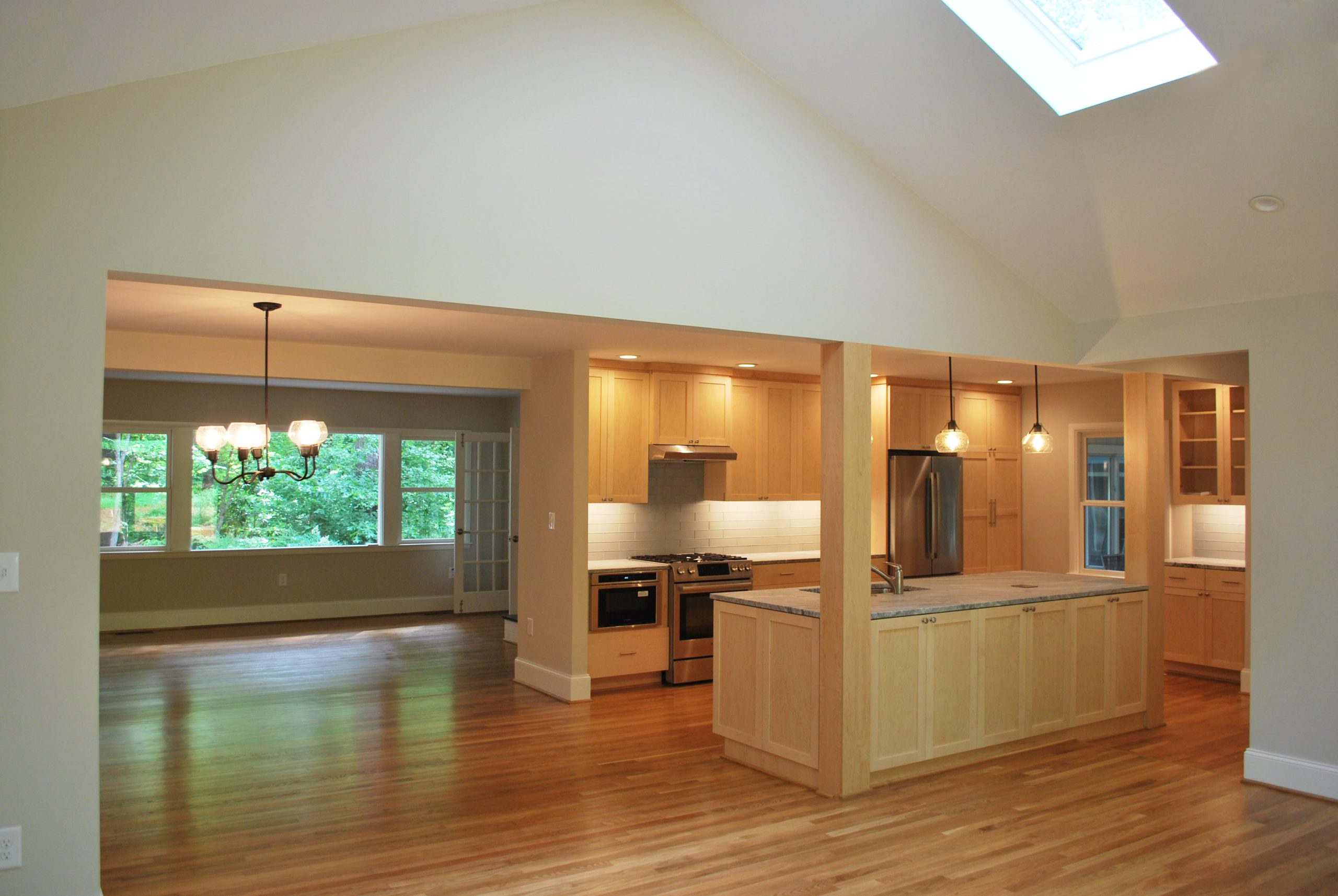 The living space is open to the updated kitchen, where warm wood cabinets compliment the original hardwood floors
