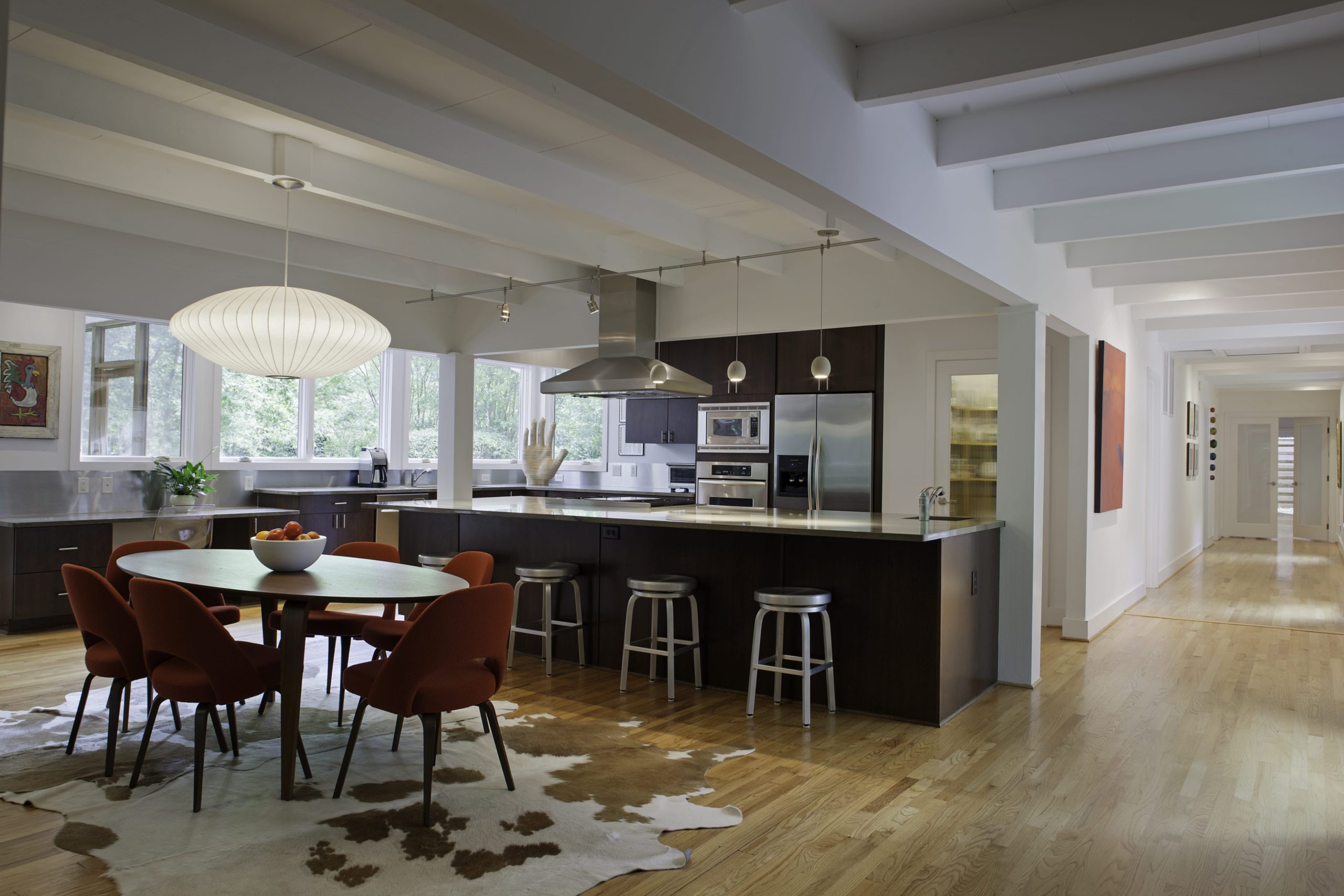 Contemporary kitchen with large island, bar seating, dining nook and large windows overlooking site