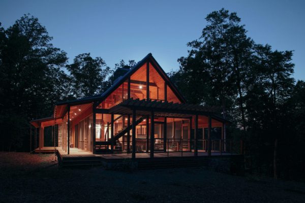 Expansive screen porch with vaulted ceiling glowing at night