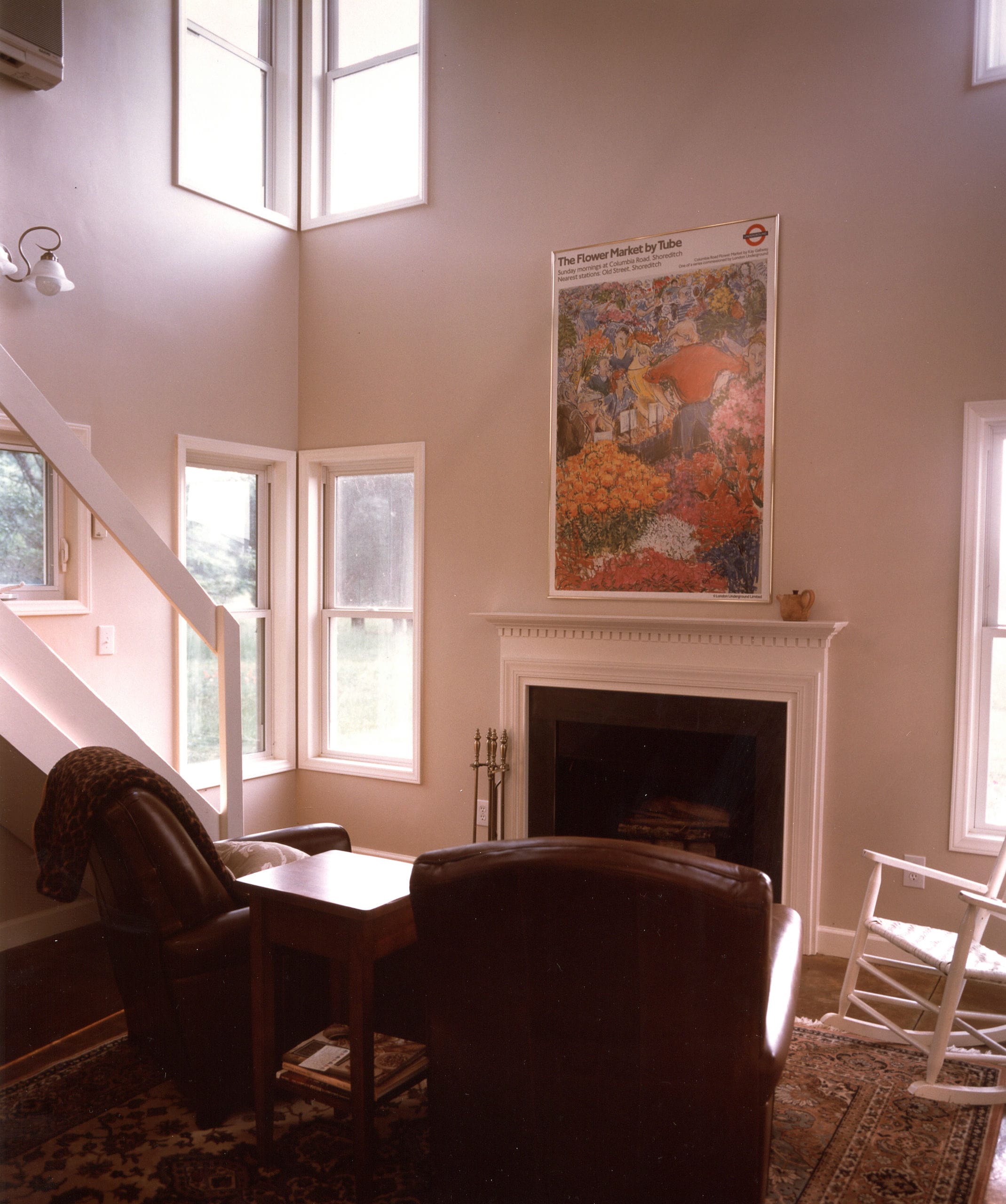 Double height sitting room with fireplace and corner windows