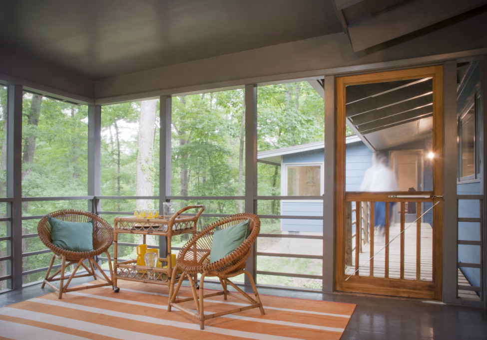 A cozy screened porch feels nestled among the trees with a covered deck connecting to the bedroom